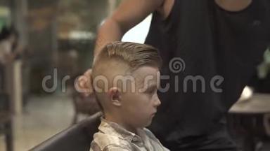 男生发型的概念。 理发师在理发店给孩子们做发型。 理发师创造男式发型